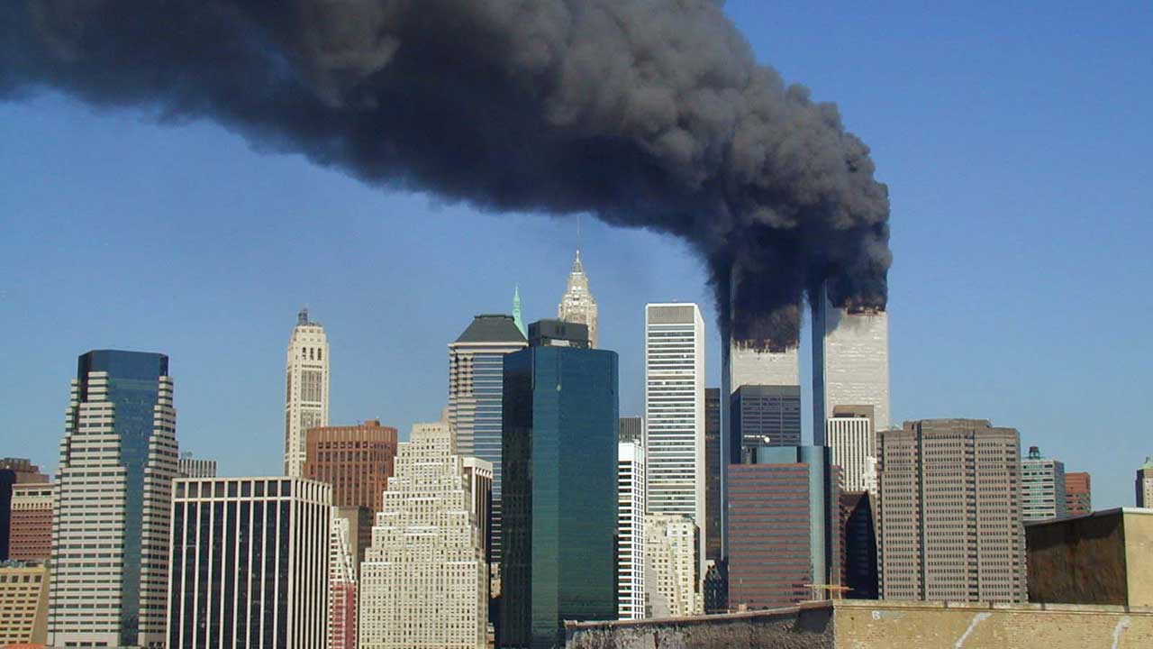 The Twin Towers of the World Trade Center billowing smoke on September 11, 2001 (Photo by Michael Foran, licensed under CC BY 2.0)